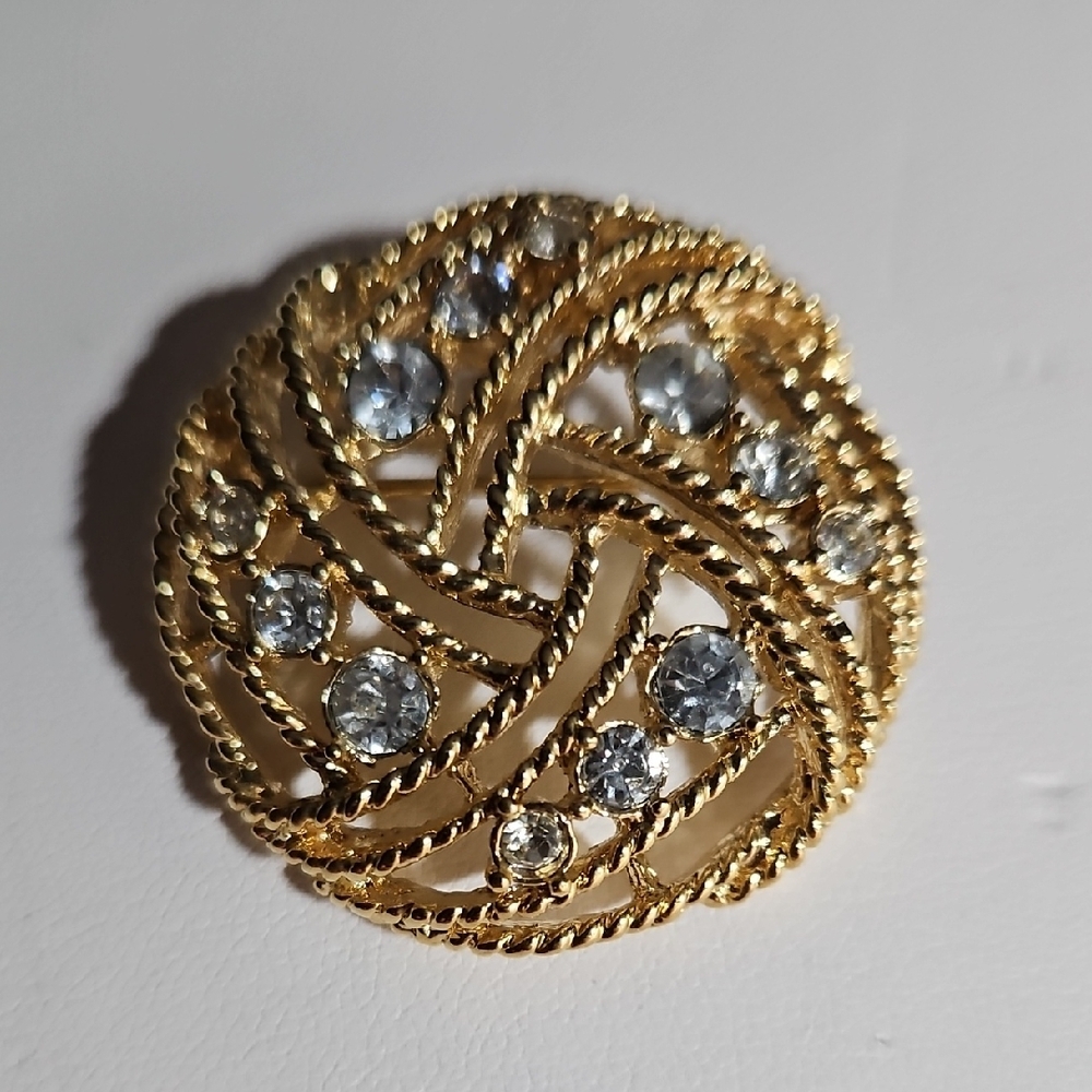 Gold Circular Brooch with Swirling Design and Sparkling Stones